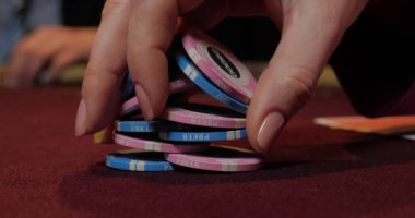 Kumarhanede poker oynayan krupiye. Eller ve cipsler masaya yakın olsun.