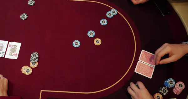 Croupier playing poker in casino. Close-up of hands and chips on table