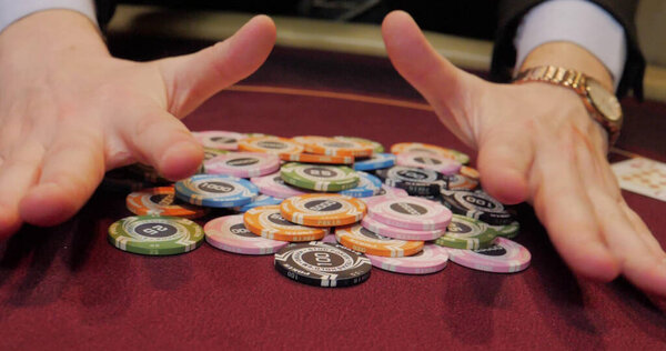 Hands of a young caucasian man playing poker at a casino