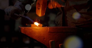 İnşaat alanındaki kaynak metalinden kıvılcımlar çıkıyor. Metal parçalarının kesilmesi ve işlenmesi.