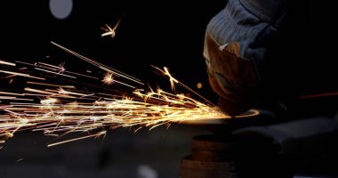 İnşaat alanındaki kaynak metalinden kıvılcımlar çıkıyor. Metal parçalarının kesilmesi ve işlenmesi. Yüksek kalite fotoğraf