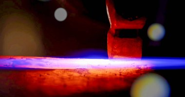 İnşaat alanındaki kaynak metalinden kıvılcımlar çıkıyor. Metal parçalarının kesilmesi ve işlenmesi. Yüksek kalite fotoğraf