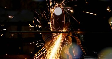 İnşaat alanındaki kaynak metalinden kıvılcımlar çıkıyor. Metal parçalarının kesilmesi ve işlenmesi. Yüksek kalite fotoğraf