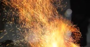 Demirci elinde kızgın demirle at nalı üzerinde çalışıyor.