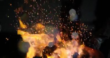 Demirci elinde kızgın demirle at nalı üzerinde çalışıyor.