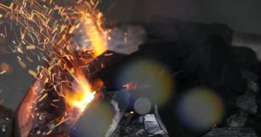 Demirci ocağında yangın, ellerin yakın çekimi.