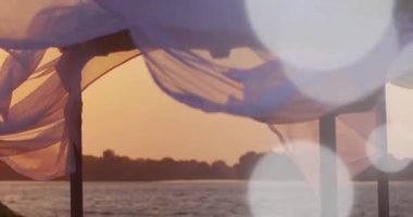 Gün batımında rüzgarda esen şeffaf bir kumaşın yakın plan çekimi.