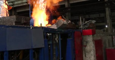 Metalürji fabrikasında çalışan bir işçi, erimiş metalle çalışıyor.