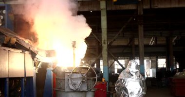 Metalürji fabrikasında çalışan bir işçi, erimiş metalle çalışıyor.