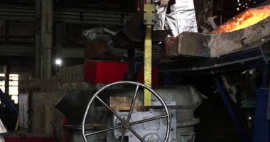 Metalürji fabrikasında çalışan bir işçi, erimiş metalle çalışıyor.