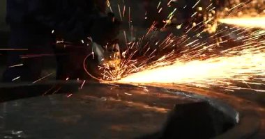 Erkek el nargile parçaları açısı öğütücü ile keser. Bir çelik inşaat alanında kıvılcım sıçraması ile kesme. Metal açılı taşlama kesim sırasında kıvılcım