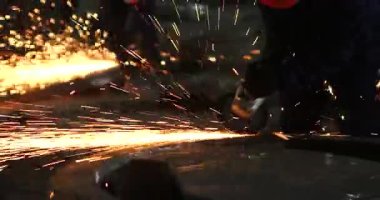 Erkek el nargile parçaları açısı öğütücü ile keser. Bir çelik inşaat alanında kıvılcım sıçraması ile kesme. Metal açılı taşlama kesim sırasında kıvılcım