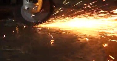 Erkek el nargile parçaları açısı öğütücü ile keser. Bir çelik inşaat alanında kıvılcım sıçraması ile kesme. Metal açılı taşlama kesim sırasında kıvılcım