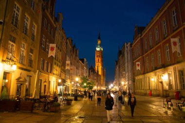 Scenic summer evening panorama of architectural pedestrians tourists people walk along the evening street of the Old Town GDANSK, POLAND - July 6, 2022