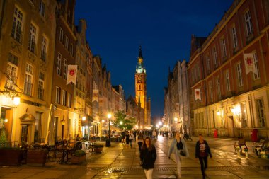 Scenic summer evening panorama of architectural pedestrians tourists people walk along the evening street of the Old Town GDANSK, POLAND - July 6, 2022