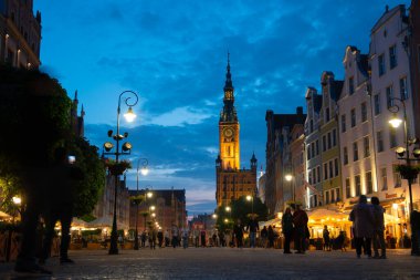 Scenic summer evening panorama of architectural pedestrians tourists people walk along the evening street of the Old Town GDANSK, POLAND - July 6, 2022