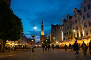 Scenic summer evening panorama of architectural pedestrians tourists people walk along the evening street of the Old Town GDANSK, POLAND - July 6, 2022