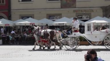 Krakow 'un ana pazar meydanının manzarası, güneşli bir günde yürüyen insanlar. Krakow, Polonya. 15.09.2023.