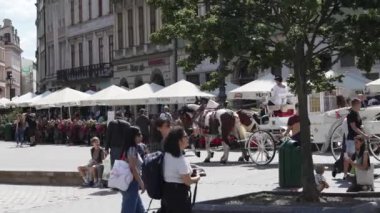 Krakow 'un ana pazar meydanının manzarası, güneşli bir günde yürüyen insanlar. Krakow, Polonya. 15.09.2023.