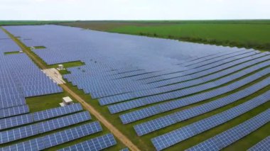 Temiz elektrik üretmek için birçok sıra güneş fotovoltaik paneli olan büyük bir enerji santralinin havadan görünüşü. Sıfır emisyonlu yenilenebilir elektrik