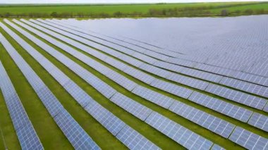 Temiz elektrik üretmek için birçok sıra güneş fotovoltaik paneli olan büyük bir enerji santralinin havadan görünüşü. Sıfır emisyonlu yenilenebilir elektrik