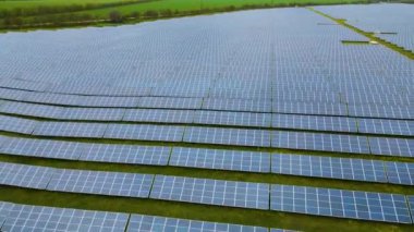 Temiz elektrik üretmek için birçok sıra güneş fotovoltaik paneli olan büyük bir enerji santralinin havadan görünüşü. Sıfır emisyonlu yenilenebilir elektrik