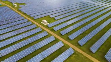 Temiz elektrik üretmek için birçok sıra güneş fotovoltaik paneli olan büyük bir enerji santralinin havadan görünüşü. Sıfır emisyonlu yenilenebilir elektrik