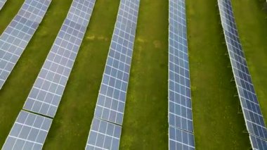 Temiz elektrik üretmek için birçok sıra güneş fotovoltaik paneli olan büyük bir enerji santralinin havadan görünüşü. Sıfır emisyonlu yenilenebilir elektrik