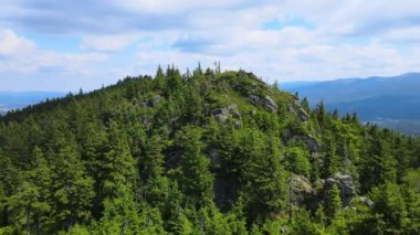 Yükselen kaya oluşumları, Almanya 'daki Sakson İsviçre Dağları' nda açık bir gökyüzünün altında yemyeşil bir ormanın ortasında duruyor..