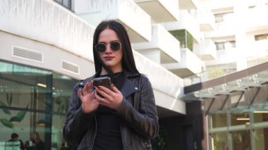 Kız gider ve akıllı telefon modern şehir işlerinde çalışır.