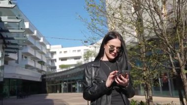 Kız gider ve akıllı telefon modern şehir işlerinde çalışır.