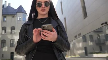 Kız gider ve akıllı telefon modern şehir işlerinde çalışır.