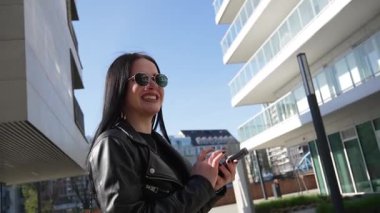 Kız gider ve akıllı telefon modern şehir işlerinde çalışır.