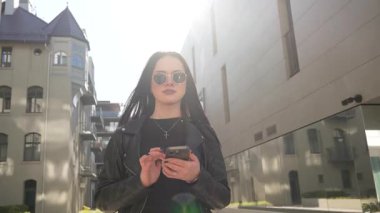 Kız gider ve akıllı telefon modern şehir işlerinde çalışır.