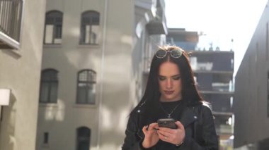 Kız gider ve akıllı telefon modern şehir işlerinde çalışır.