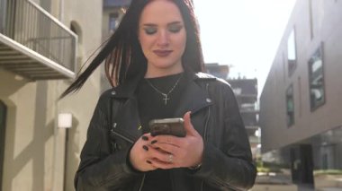 Kız gider ve akıllı telefon modern şehir işlerinde çalışır.
