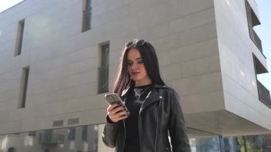 Kız gider ve akıllı telefon modern şehir işlerinde çalışır.