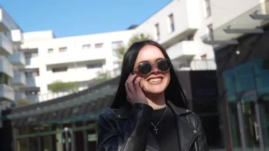 Kız telefonda yürüyor ve konuşuyor. Modern şehir işleri.