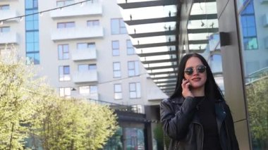 Kız telefonda yürüyor ve konuşuyor. Modern şehir işleri.