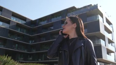 Kız telefonda yürüyor ve konuşuyor. Modern şehir işleri.