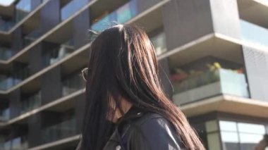 Kız telefonda yürüyor ve konuşuyor. Modern şehir işleri.