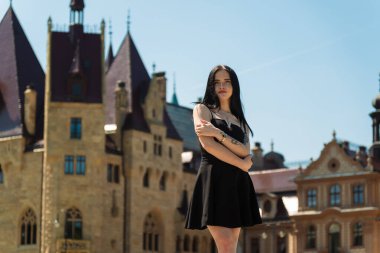 Kalenin arka planında siyah elbiseli güzel bir kız.