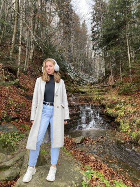 Genç kız ormanda yürüyor. 