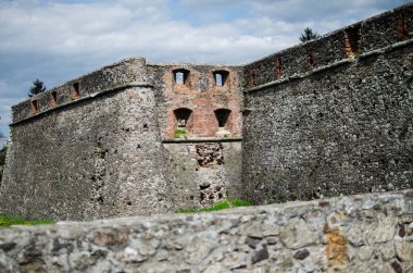 Boya soyan ve kırık camları olan terk edilmiş eski bir bina. Harabeler yoğun bitki örtüsüyle çevrilidir ve yavaş yavaş yerleşkeyi ele geçirirler. Gizem ve ihmal dolu bir atmosfer..