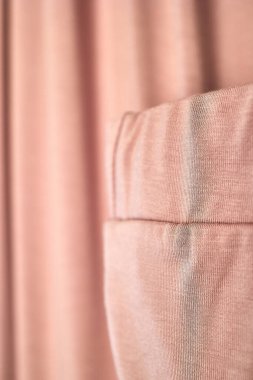Pembe kumaşın yakın plan görüntüsü, dikişlerin dokusunu ve dikişlerini vurguluyor.