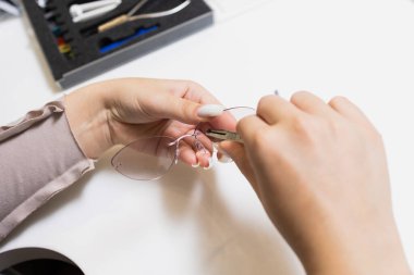 Bu resim düzgün bir gözlük bakımının önemini vurgular, çerçeveyi onarma sürecini gösterir.