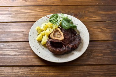 Bu görüntüde lezzetli bir Osso Buco tabağı sergileniyor. Yumuşak dana bacakları kusursuzca pişirilmiş.