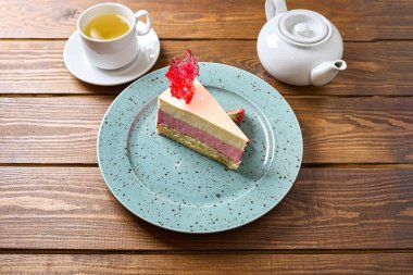 Bir fincan çayla servis edilen farklı tat ve dokulara sahip lezzetli bir dilim pasta. Öğleden sonra ikramı ya da özel bir gün için mükemmel..