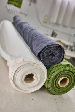 Çeşitli renklerde kumaş ruloları bir giyim üretim tesisinde kullanılmayı bekliyor