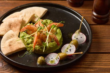 Güzel sunulmuş avokado ve karides karışımı ile nefis bir aperatif, sıcak pita ekmeğiyle servis edilir.